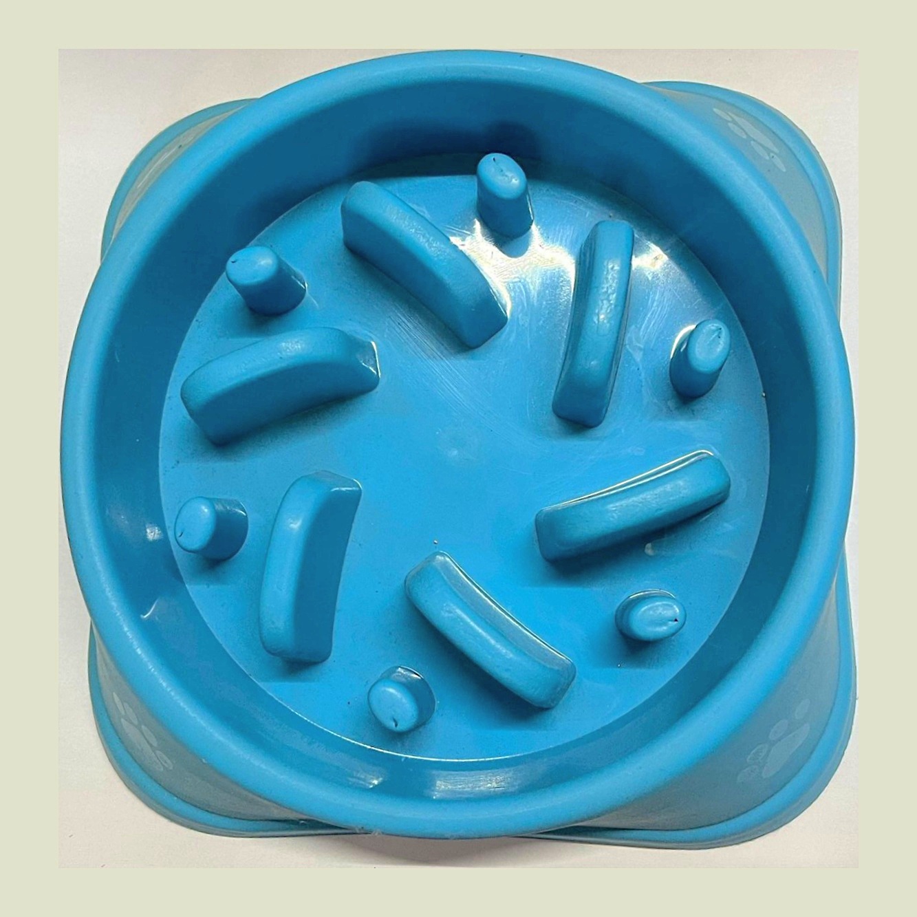 A blue slow-feeder dog bowl with raised channels